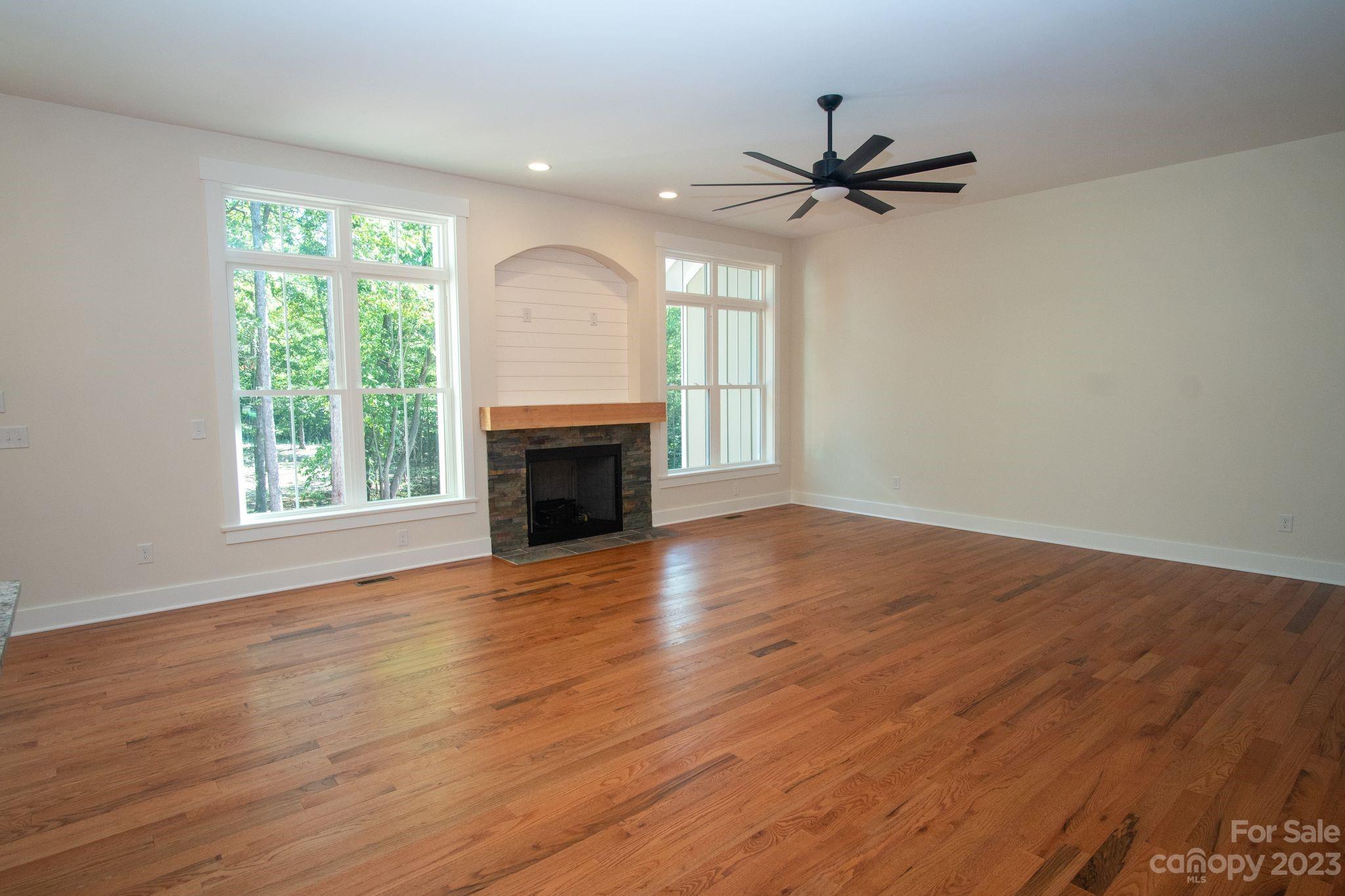 1495 Golf Course Road Columbus, NC 28722 - Photo 21 of 47 a view of empty room with wooden floor fireplace and a window