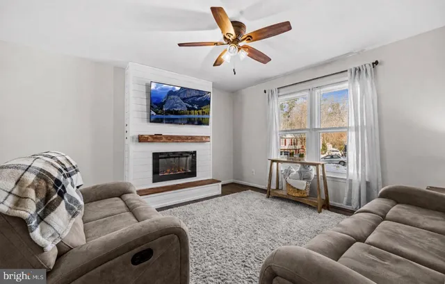 a living room with furniture a fireplace and a flat screen tv