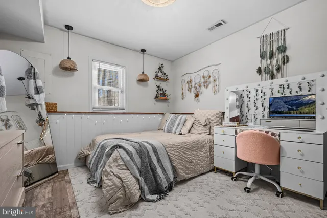 a bedroom with a bed a couch and dresser