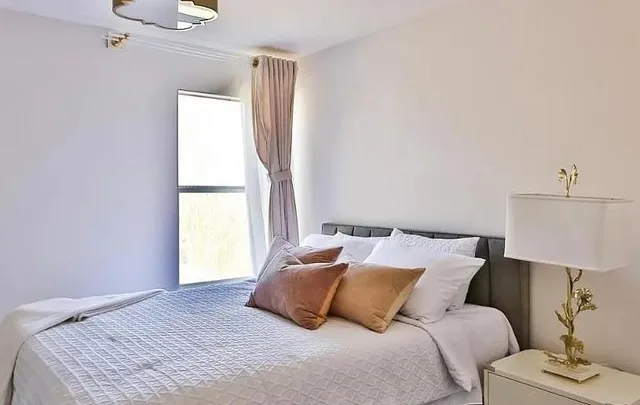 a bedroom with a bed and a window