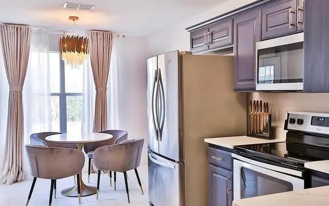 a kitchen with stainless steel appliances granite countertop a refrigerator and a stove top oven