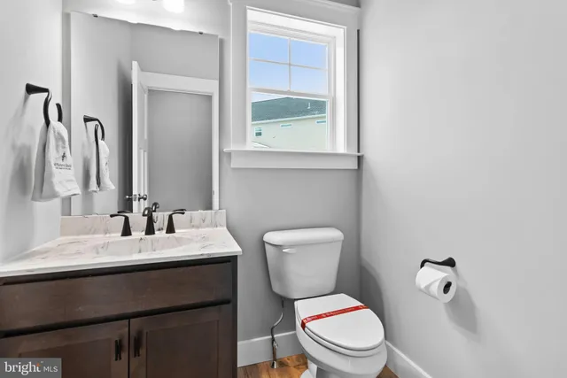 a bathroom with a granite countertop toilet sink and mirror
