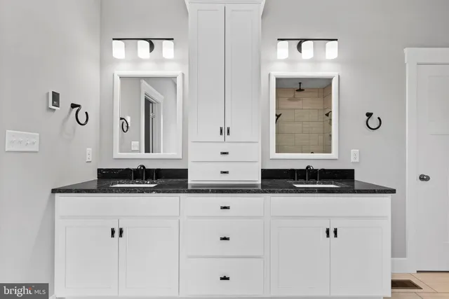 a spacious bathroom with a double vanity sink a mirror and a bathtub