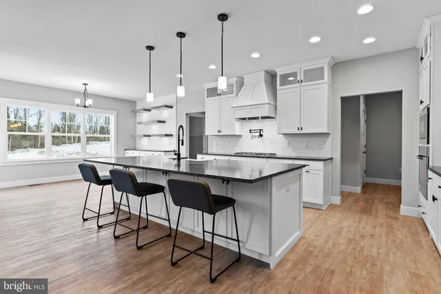 a kitchen with kitchen island granite countertop a sink cabinets and wooden floor