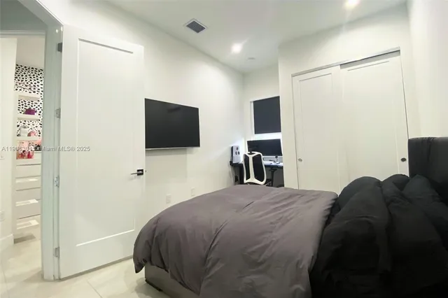 a bedroom with a bed and a flat screen tv