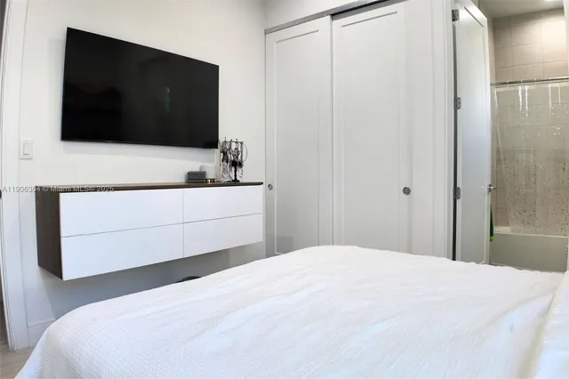 a bedroom with a bed and a flat screen tv