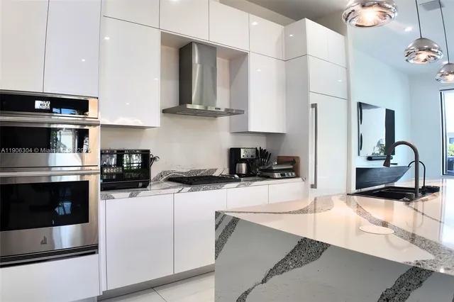 a view of a dining room with furniture a chandelier and large windows