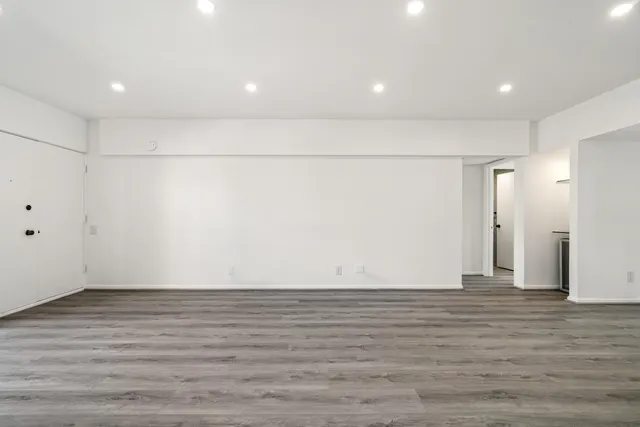 a view of a kitchen with stainless steel appliances wooden floor and large windows