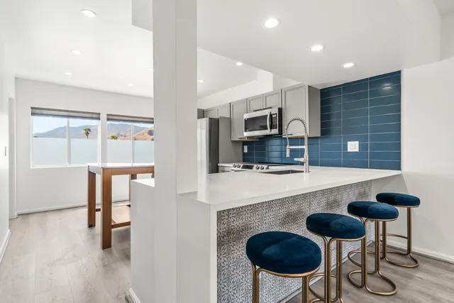 a kitchen with stainless steel appliances granite countertop a stove a refrigerator and a sink