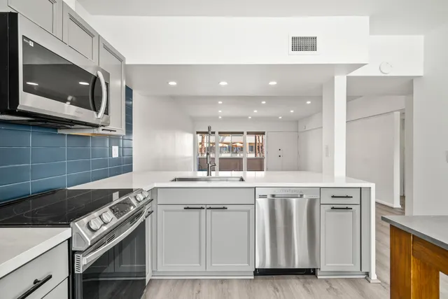 a kitchen with white cabinets and white appliances