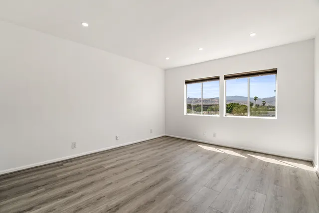 an empty room with wooden floor and window