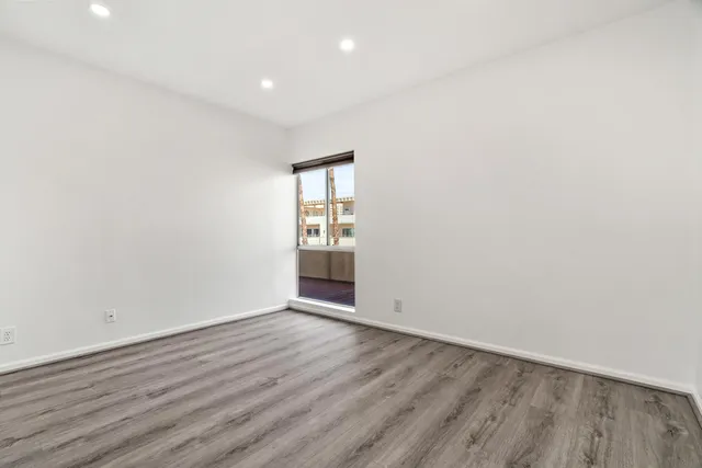 an empty room with wooden floor and closet
