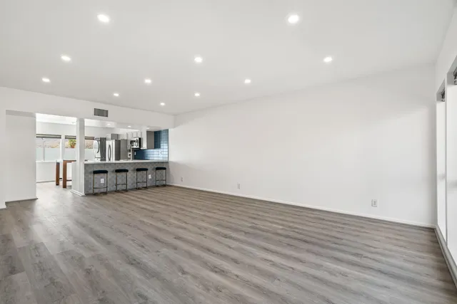 a living room with furniture and view of kitchen