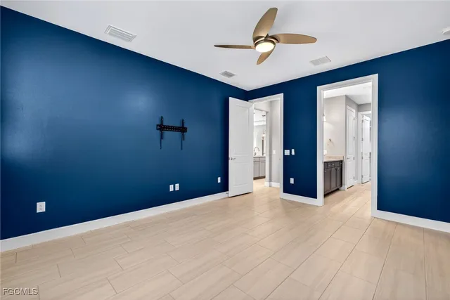 a view of an empty room with a chandelier fan