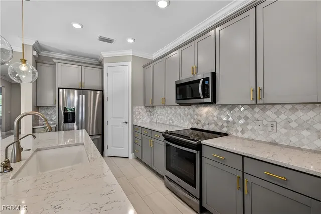 a kitchen with granite countertop a sink stainless steel appliances and cabinets