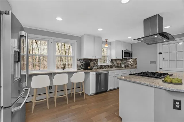 a kitchen with a stove a table and chairs in it