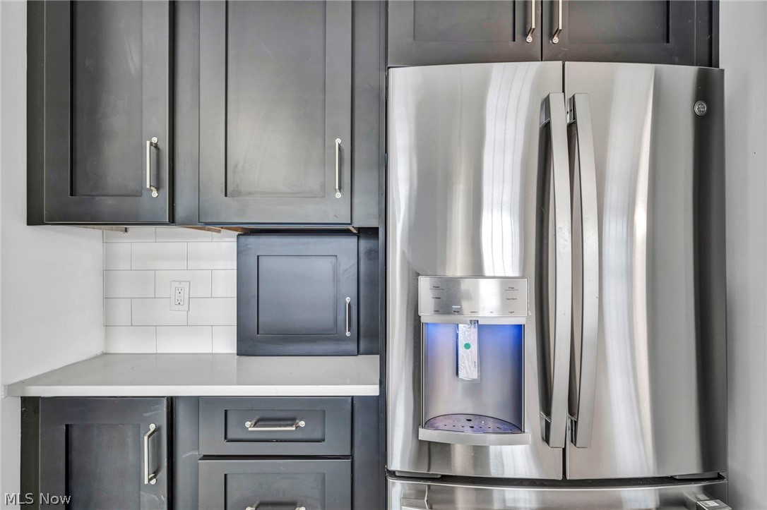 2135 Coventry Road, Unit DOWN Cleveland, OH 44118 - Photo 16 of 34 Kitchen featuring stainless steel fridge with ice dispenser, light stone counters, and tasteful backsplash
