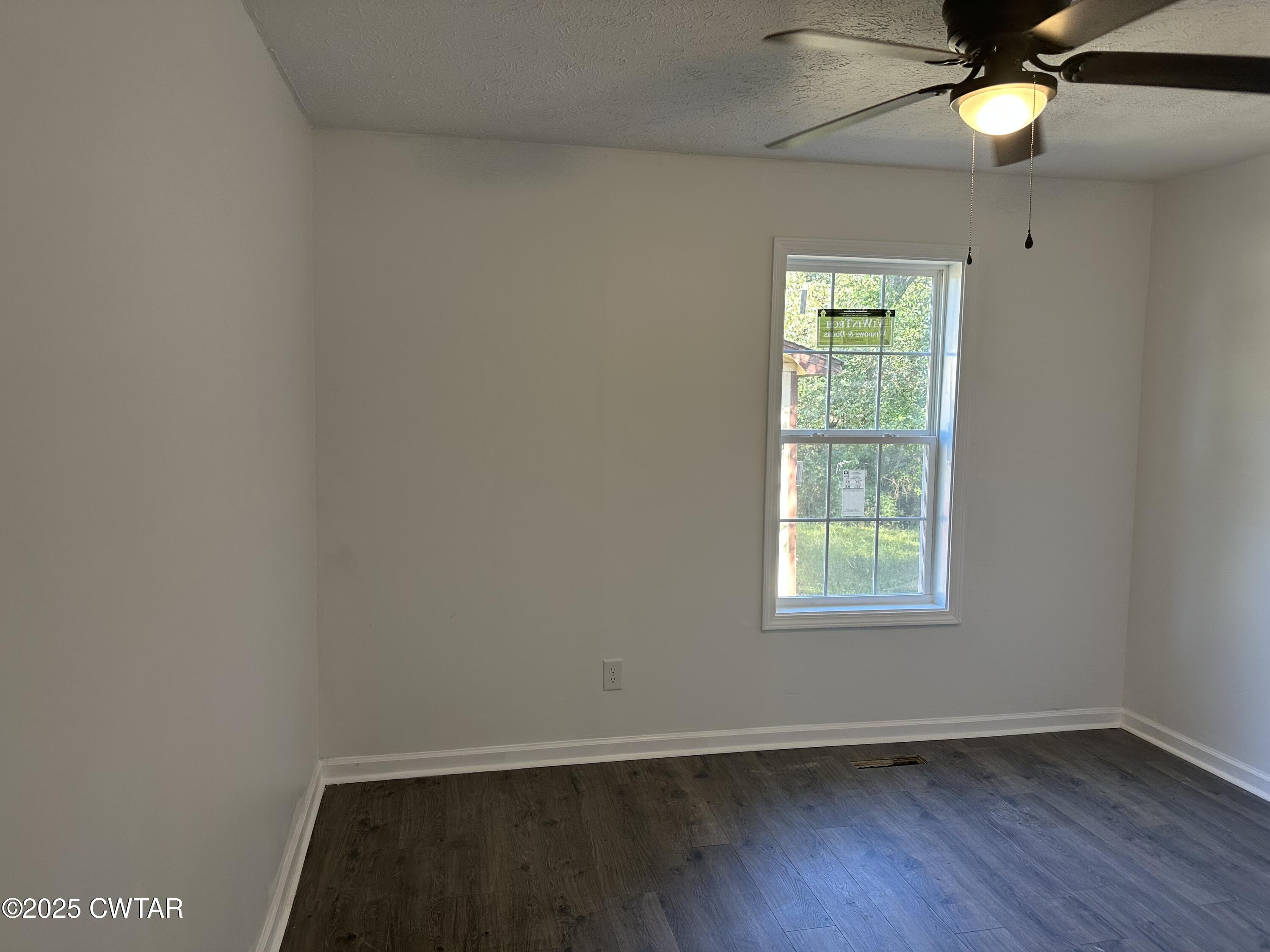 328 Baughn Street Henderson, TN 38340 - Photo 11 of 16 an empty room with a window and wooden floor