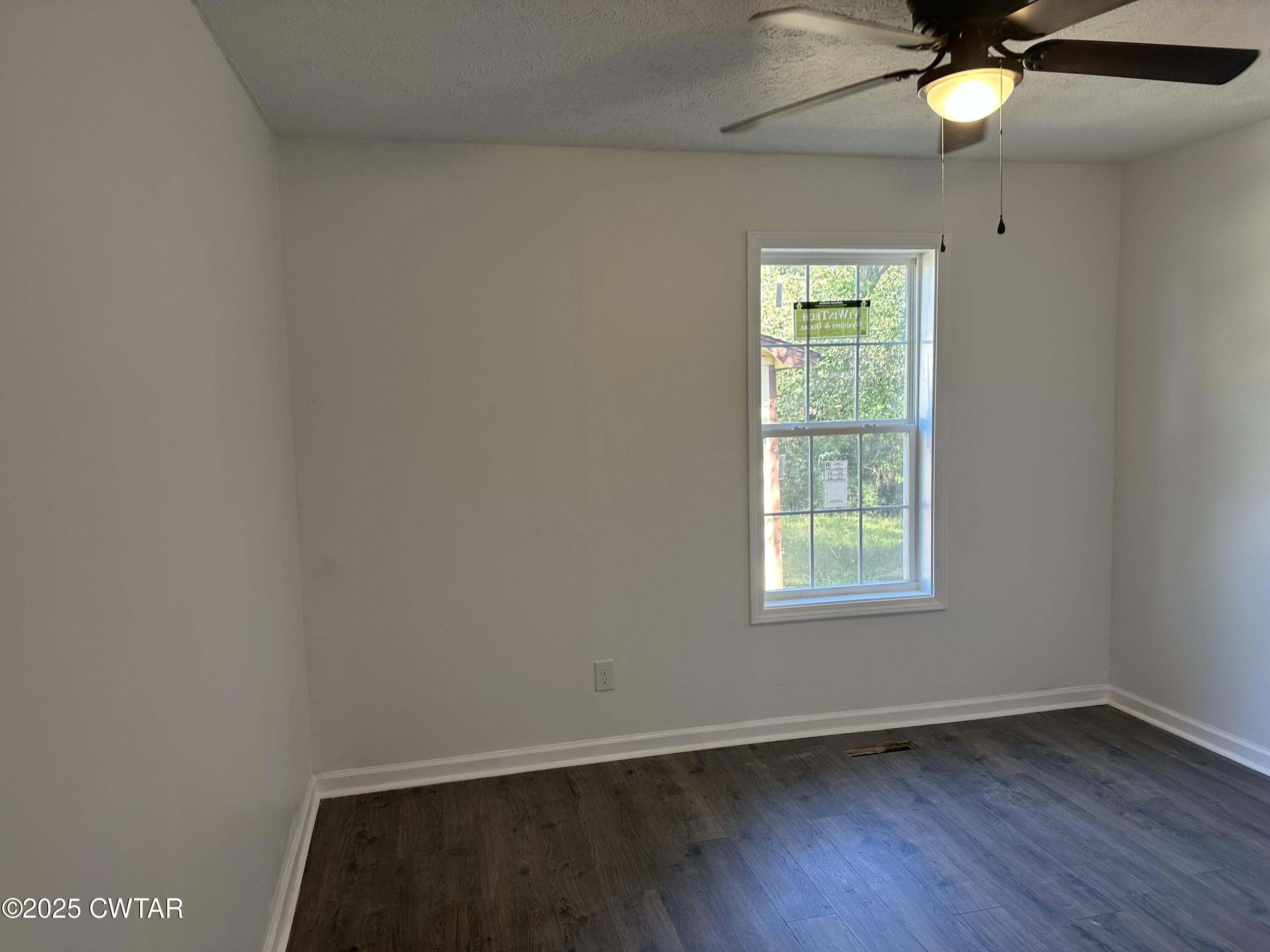 328 Baughn Street Henderson, TN 38340 - Photo 12 of 16 an empty room with wooden floor and windows