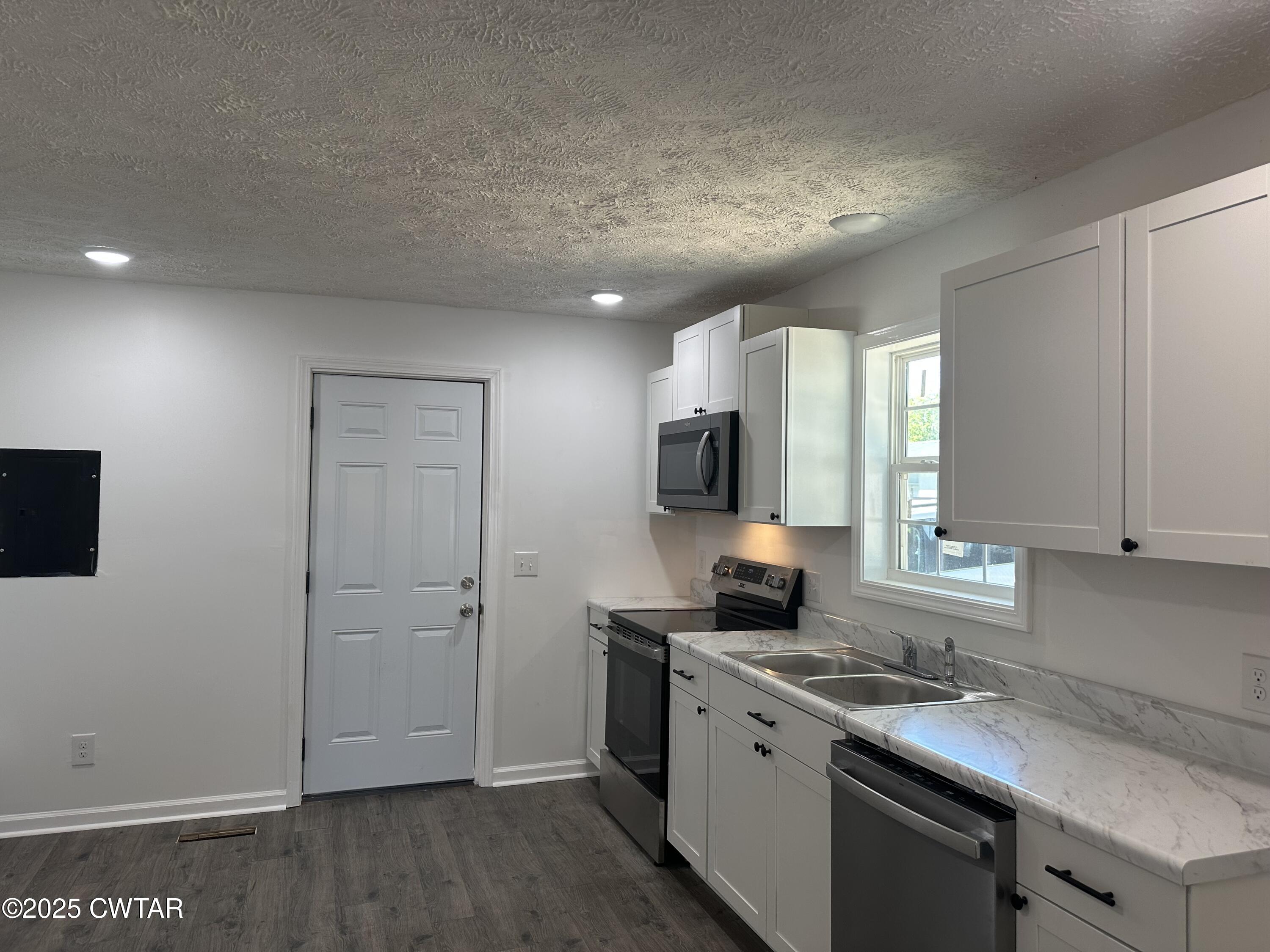 328 Baughn Street Henderson, TN 38340 - Photo 4 of 16 a kitchen with a sink cabinets and appliances