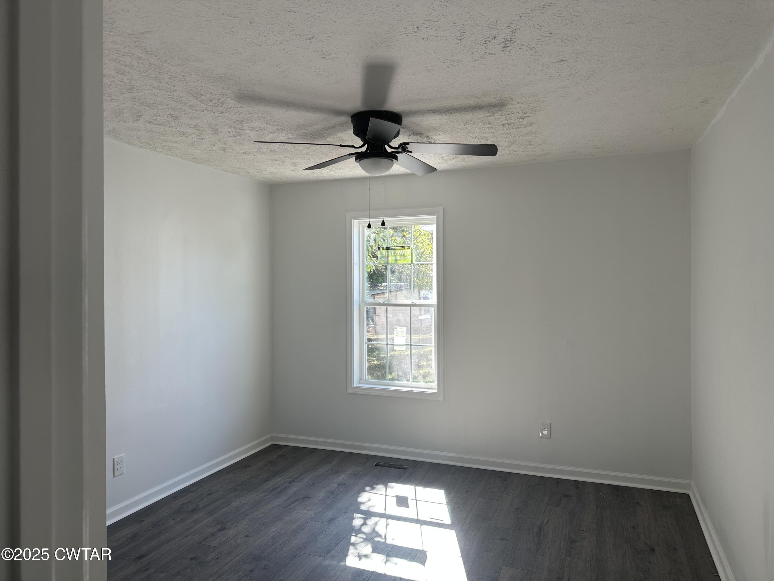 328 Baughn Street Henderson, TN 38340 - Photo 9 of 16 an empty room with a window and a ceiling fan