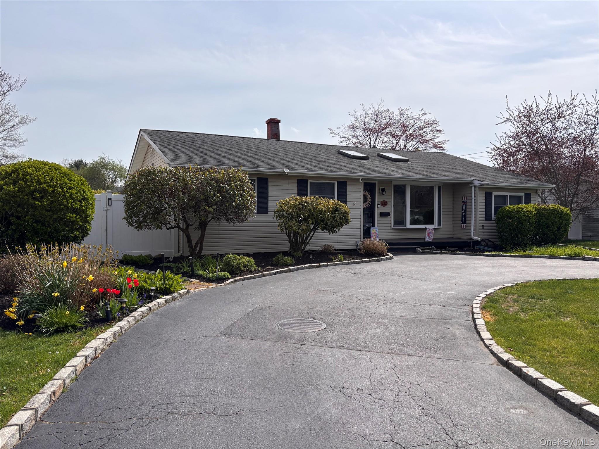 212 Matthews Road Oakdale, NY 11769 - Photo 2 of 7 Front exterior featuring light-toned siding and a dark shingle roof