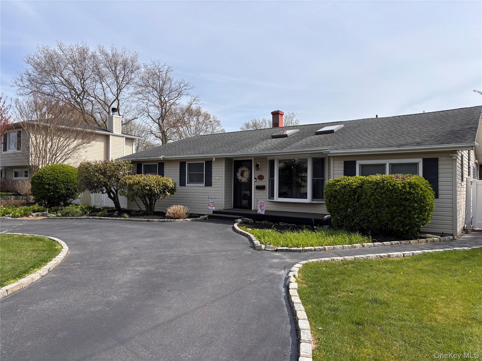 212 Matthews Road Oakdale, NY 11769 - Photo 3 of 7 Ranch-style 2014sq ft residence featuring light-toned siding and a dark shingle roof with skylights