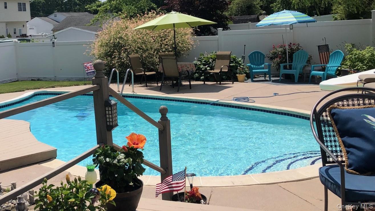 212 Matthews Road Oakdale, NY 11769 - Photo 5 of 7 In-ground swimming pool with integrated steps and surrounding concrete patio
