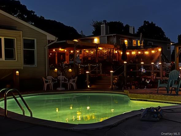212 Matthews Road Oakdale, NY 11769 - Photo 6 of 7 Illuminated inground swimming pool with integrated steps and concrete surround