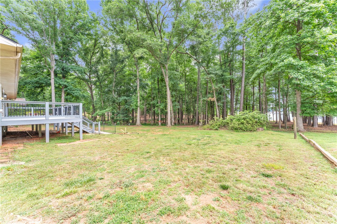 4416 Denver Cove Road Anderson, SC 29625 - Photo 25 of 31 Discover a tranquil backyard haven with a spacious deck overlooking a lush, wooded landscape leading to the waterfront.