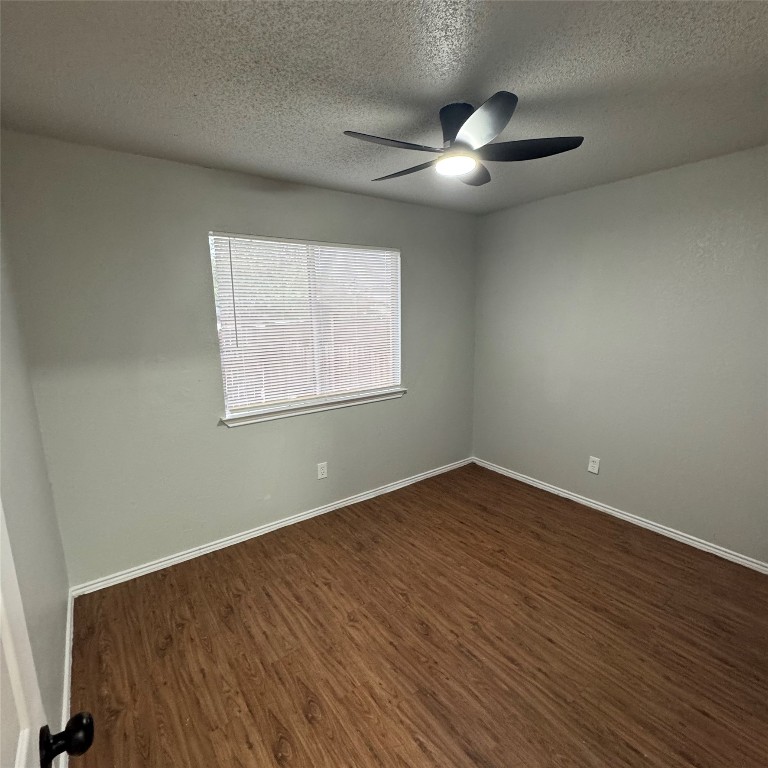 1212 Orchard Park Circle Pflugerville, TX 78660 - Photo 4 of 6 a view of an empty room with wooden floor and a window