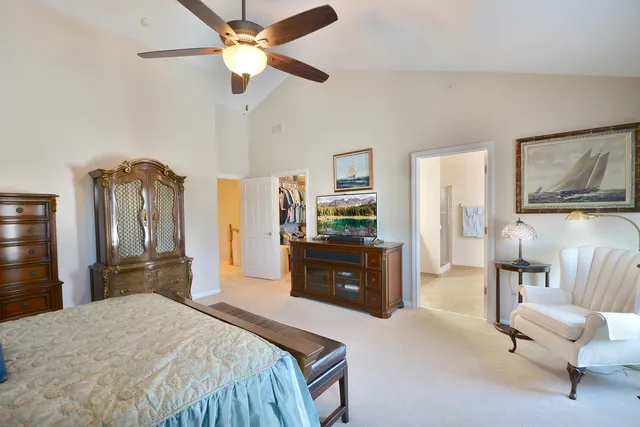 a bedroom with a bed dresser and a flat tv screen