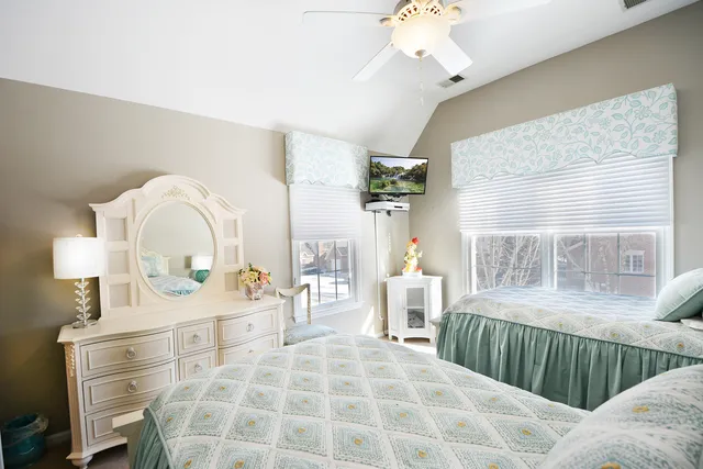 a bedroom with a bed mirror and a large window