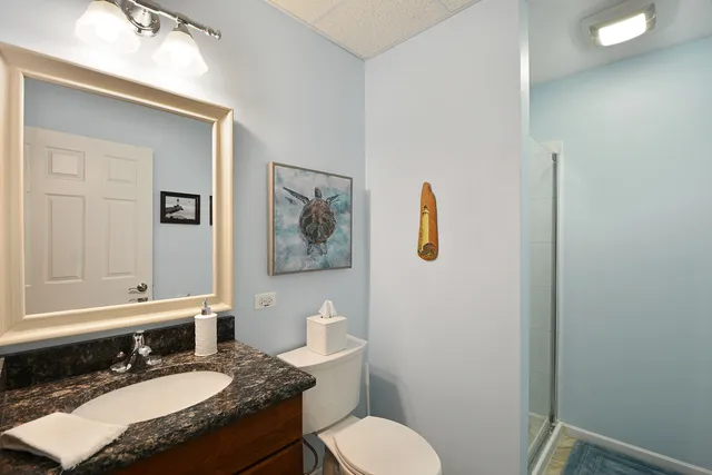 a bathroom with a granite countertop toilet sink and mirror