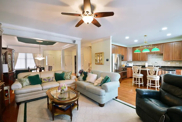 a living room with furniture kitchen view and a large window