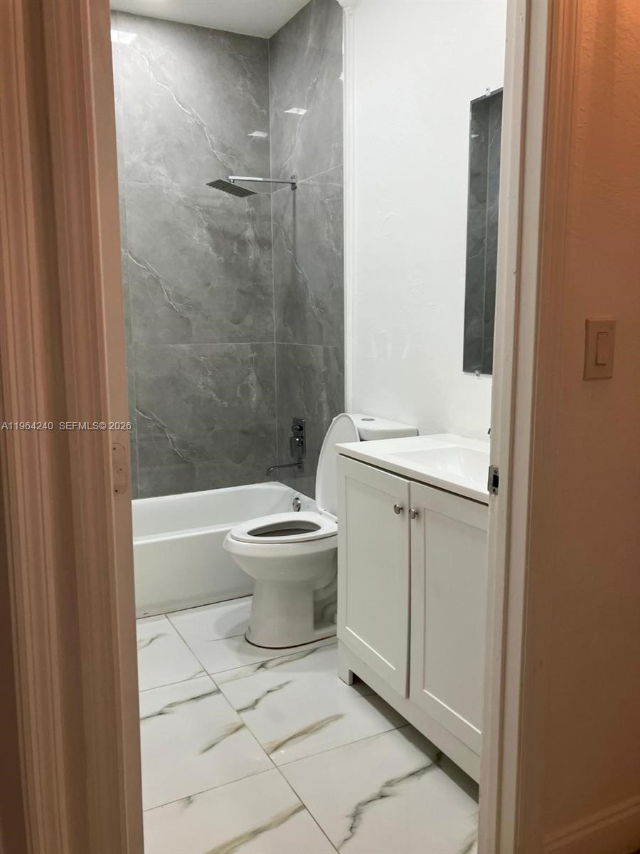620 Cypress Club Way, Unit L13 Deerfield Beach, FL 33064 - Photo 12 of 14 a bathroom with a toilet a sink and shower