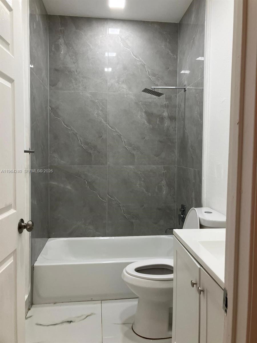 620 Cypress Club Way, Unit L13 Deerfield Beach, FL 33064 - Photo 13 of 14 a bathroom with a sink a toilet and a bathtub