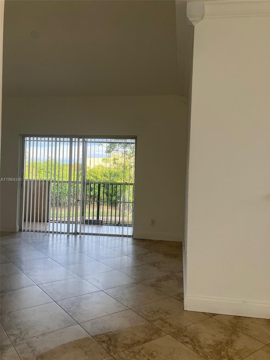 620 Cypress Club Way, Unit L13 Deerfield Beach, FL 33064 - Photo 2 of 14 an empty room with wooden floor and windows
