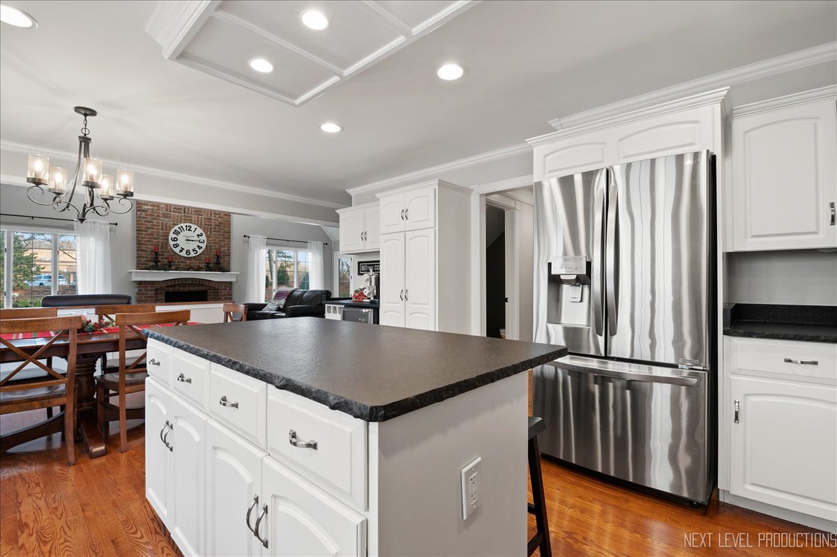 1521 Eagle Brook Drive Geneva, IL 60134 - Photo 19 of 41 a kitchen with stainless steel appliances granite countertop a refrigerator a sink dishwasher a dining table and chairs with wooden floor