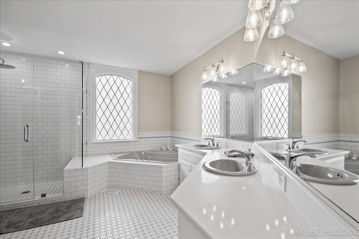 1521 Eagle Brook Drive Geneva, IL 60134 - Photo 22 of 41 a bathroom with a sink a bathtub a mirror a vanity and a shower