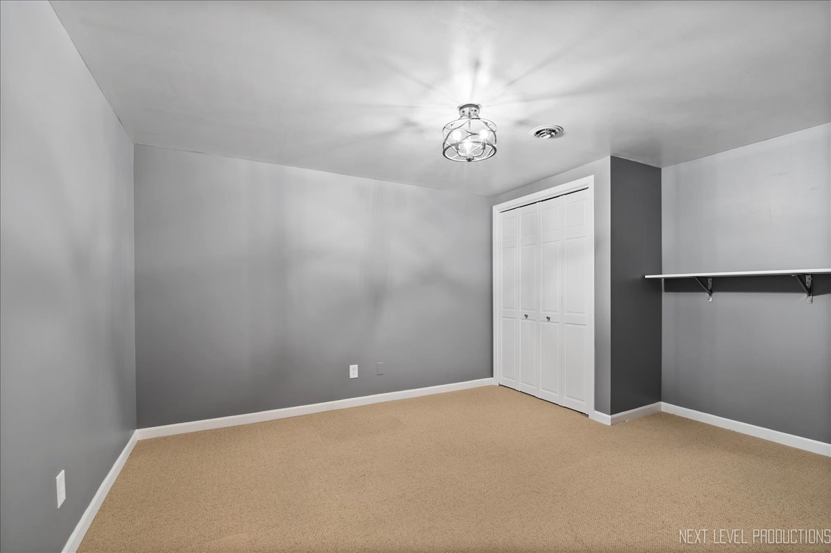 1521 Eagle Brook Drive Geneva, IL 60134 - Photo 34 of 41 an empty room with a chandelier fan