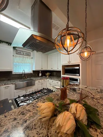 a kitchen with stainless steel appliances granite countertop a stove a sink and a microwave