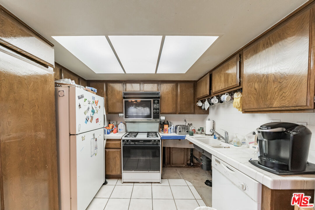 19127 Index Street, Unit 3 Porter Ranch, CA 91326 - Photo 15 of 18 a kitchen with stainless steel appliances a refrigerator sink and stove