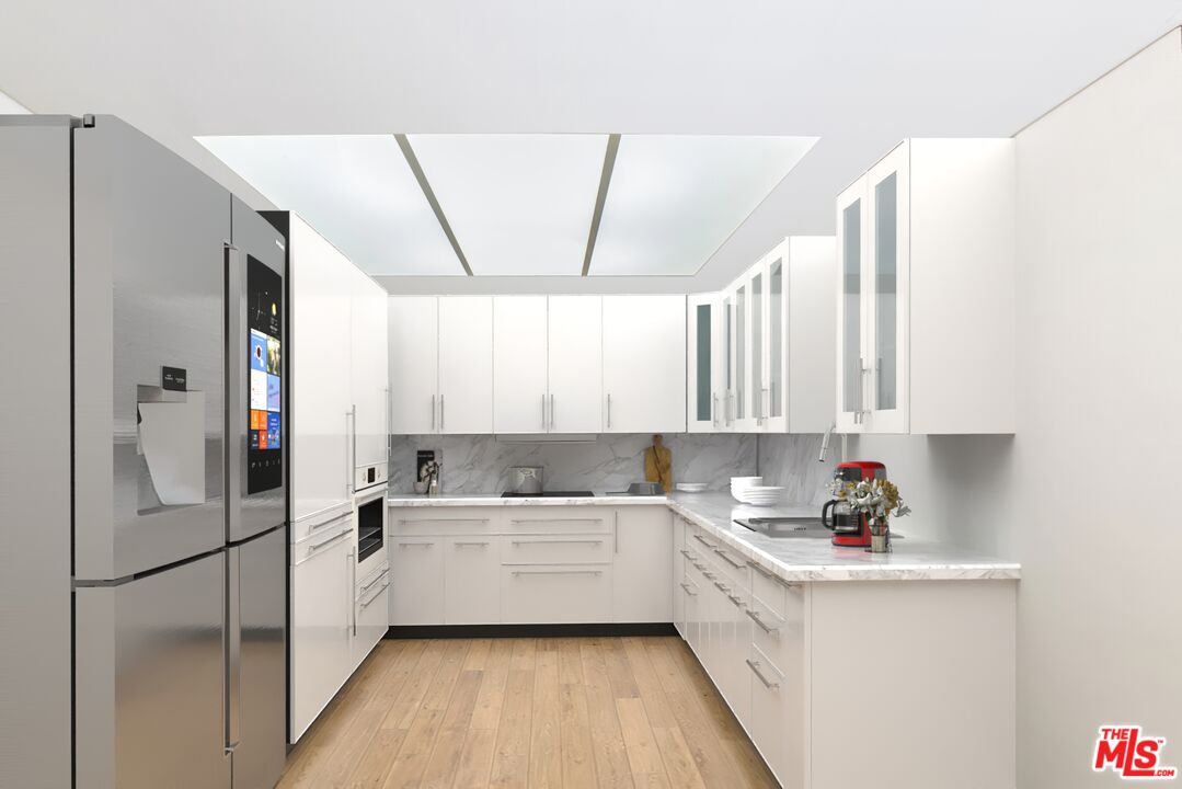 19127 Index Street, Unit 3 Porter Ranch, CA 91326 - Photo 3 of 18 a kitchen with a sink a refrigerator and cabinets