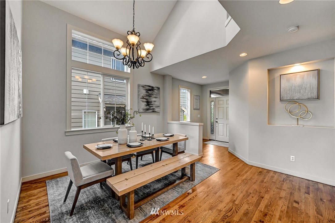 4022 167th Street Southeast Bothell, WA 98012 - Photo 6 of 34 a dining room with wooden floor a chandelier a wooden table and chairs