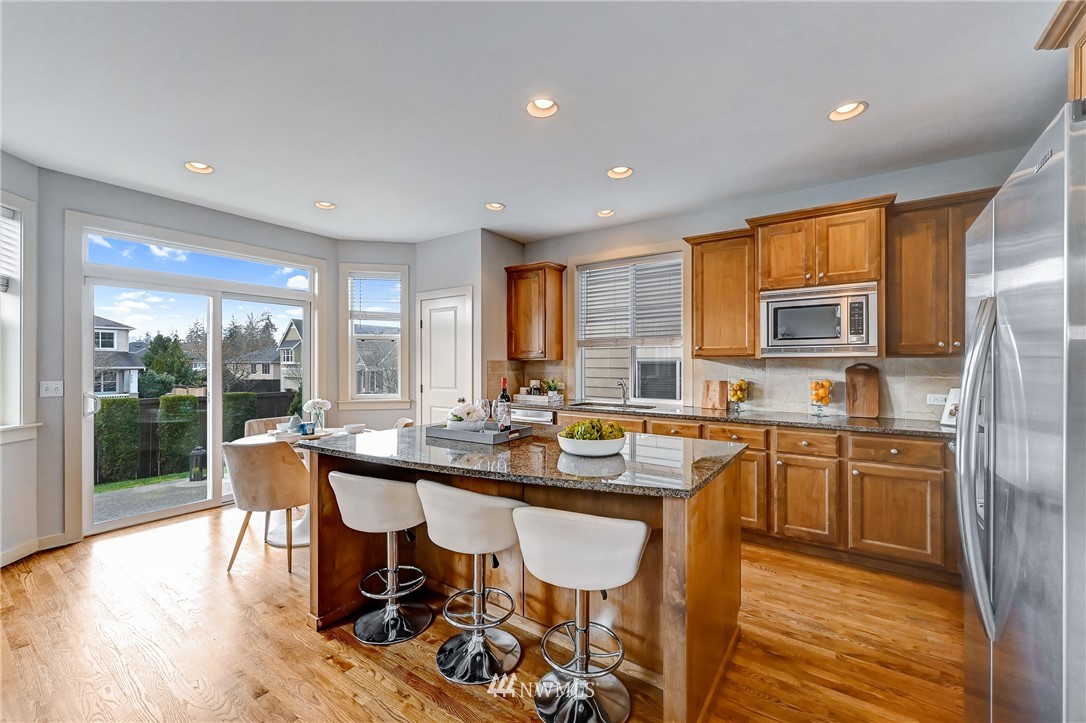 4022 167th Street Southeast Bothell, WA 98012 - Photo 8 of 34 a kitchen with stainless steel appliances granite countertop dining table chairs refrigerator and sink