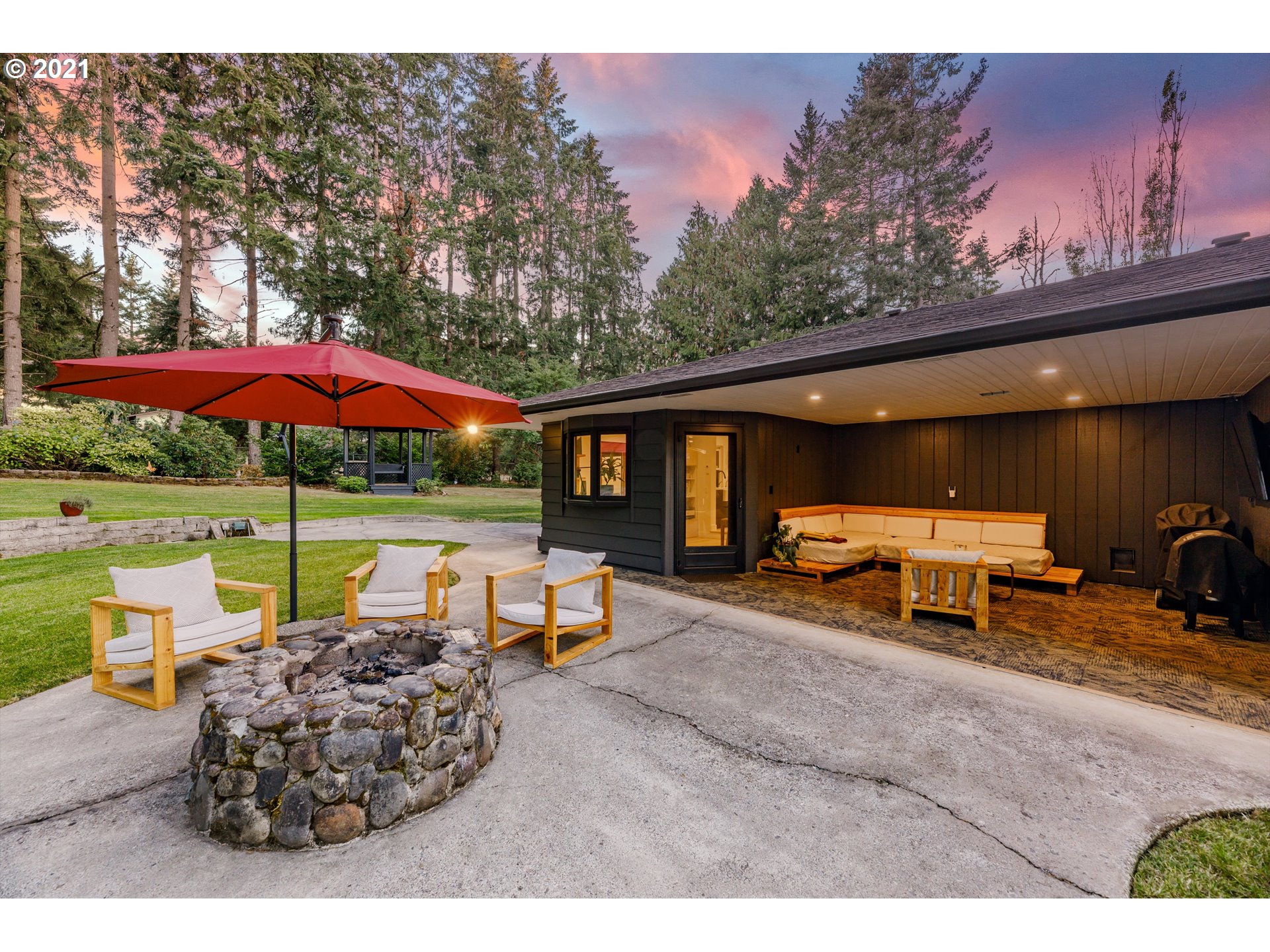 13450 Southeast Richey Road Boring, OR 97009 - Photo 26 of 32 a view of a patio with table and chairs under an umbrella with a fire pit