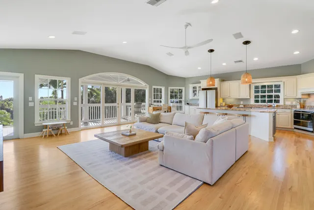 a living room with furniture kitchen view and a wooden floor