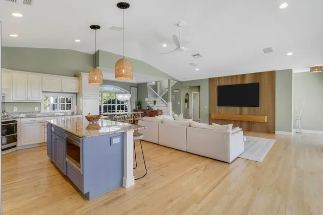 a large kitchen with stainless steel appliances granite countertop a stove and a wooden floors