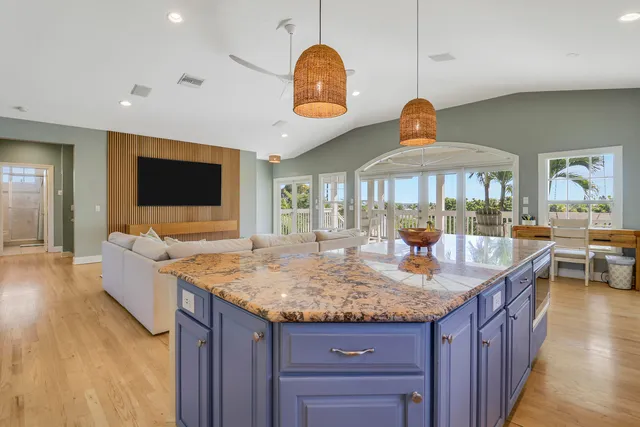 a living room with granite countertop kitchen island furniture and a flat screen tv